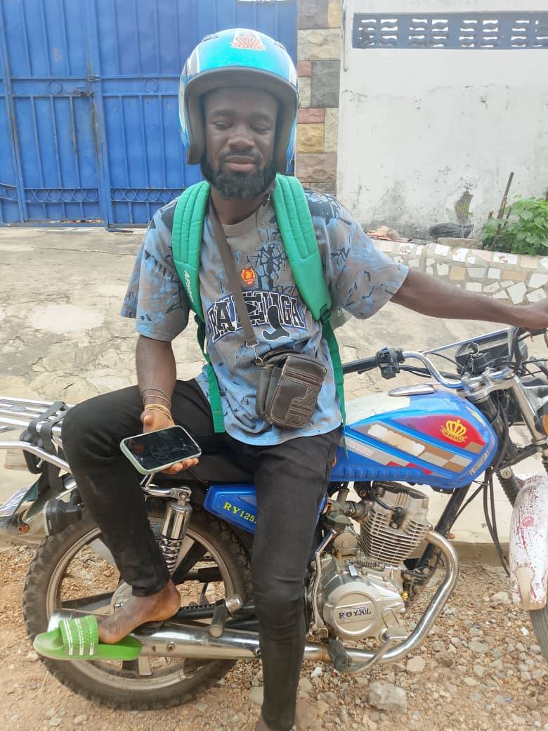 One of Grayline's riders sitting on his motorbike, phone in hand